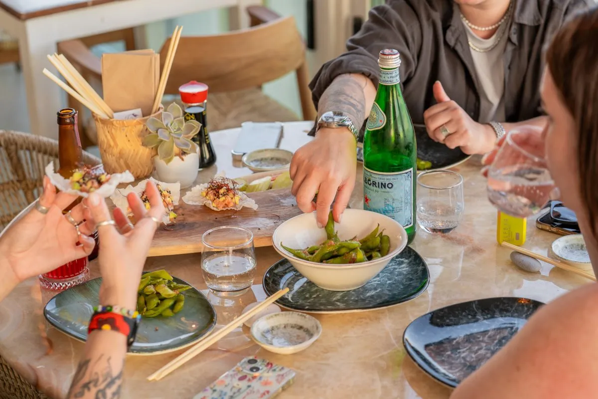 Taş masada paylaşılan edamame, sushi ve soslar, yukarıdan.